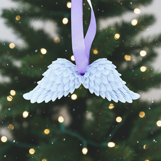 Light blue angel wings with purple ribbon and festive background