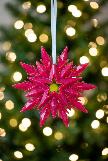 Pink snowflake with a softly blurred Christmas-tree background